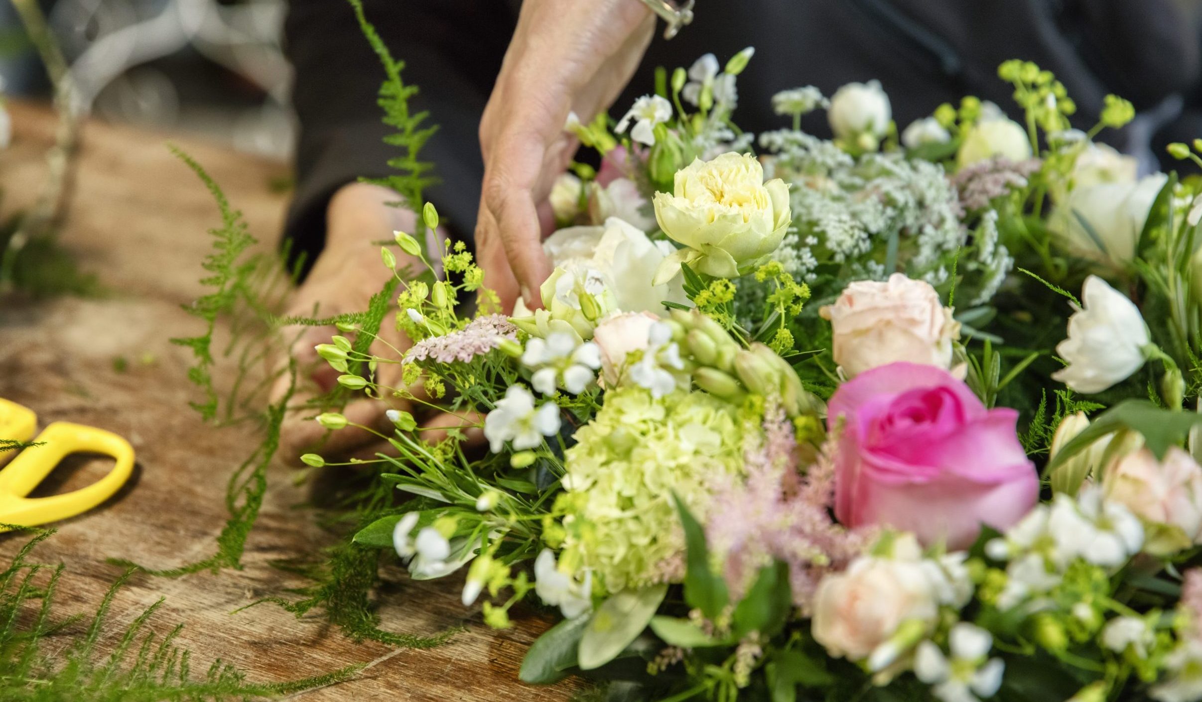A woman working on a flower arrangement, a trained florist.
